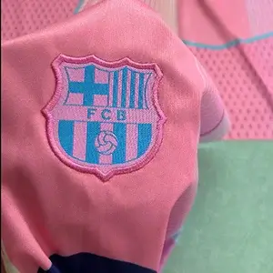 Official FC Barcelona FCB shield crest featuring professional Custom Soccer Jersey Embroidery.